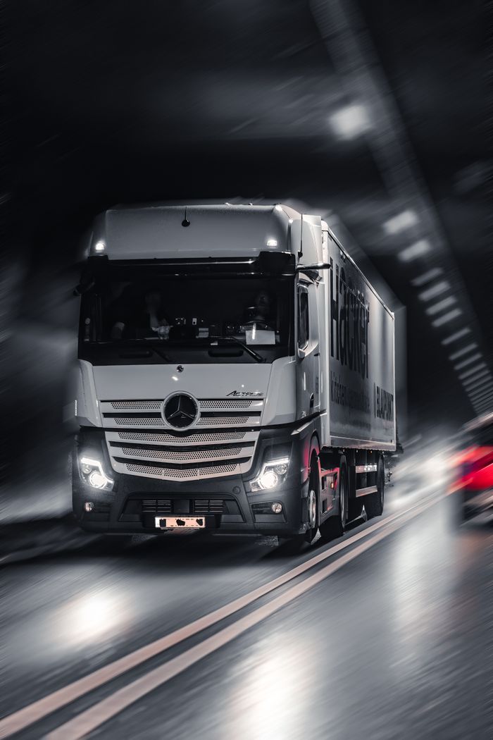 Services Mercedes-Benz Actros truck speeding through a city tunnel, capturing urban motion and energy.