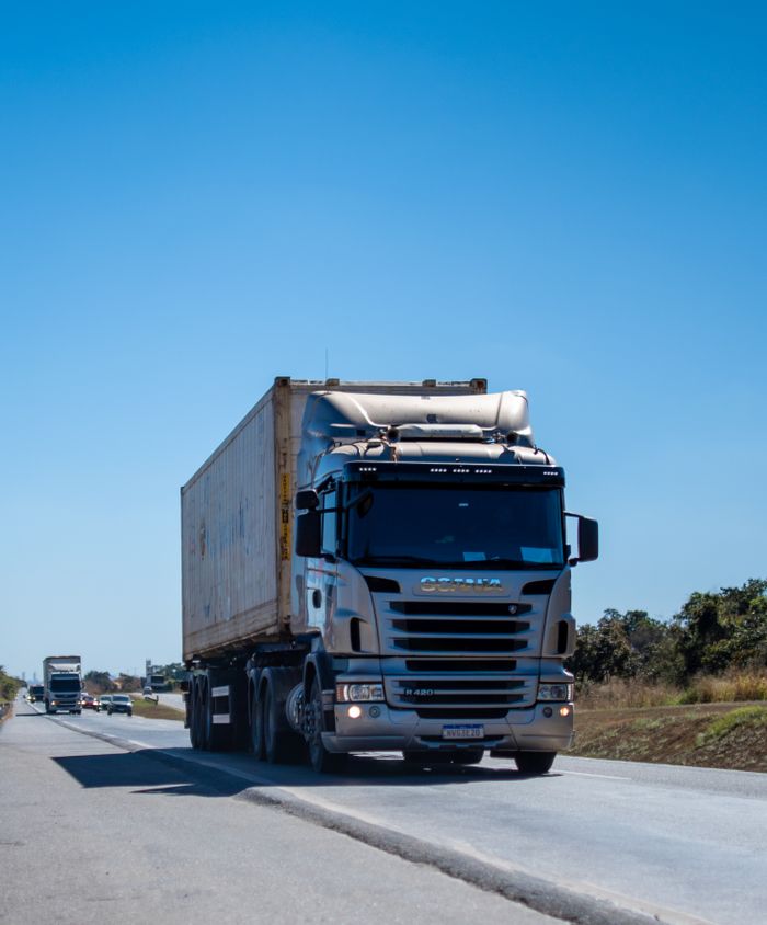 Services A large cargo truck travels on a highway in Brazil under clear blue skies.