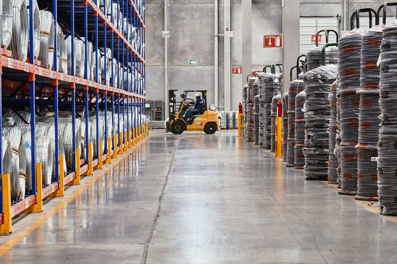 Services A forklift operates in an industrial warehouse with stacked goods. Efficient distribution setting.