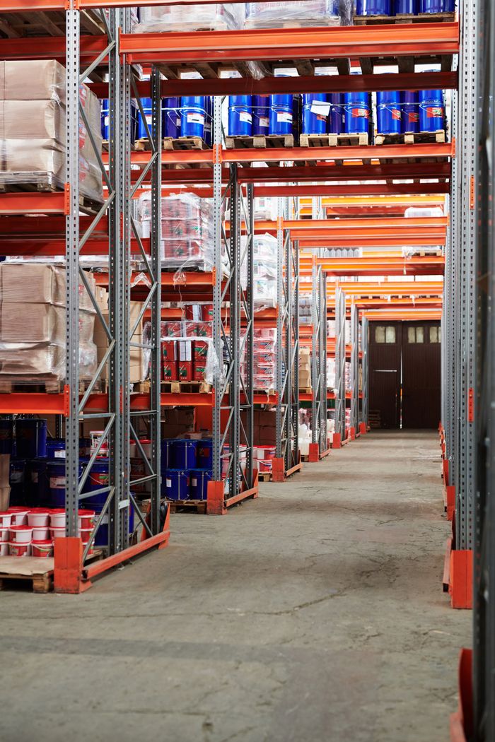 Services Industrial warehouse interior with organized shelves stacked with packages and goods.